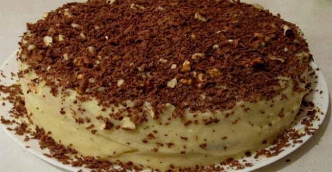 Готовый творожный торт на сковороде украшен шоколадом и орешками