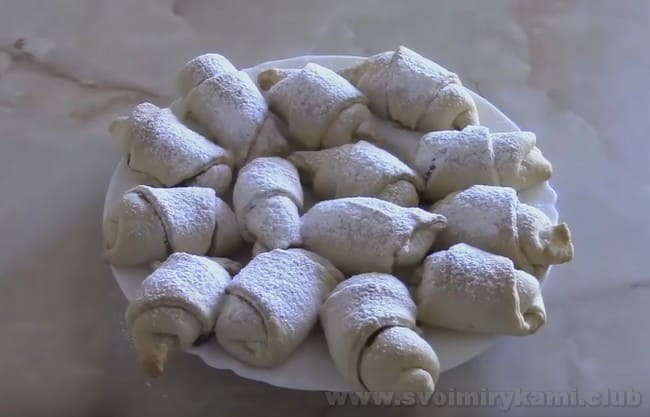 Посыпьте рогалики из песочного теста на маргарине сахарной пудрой.